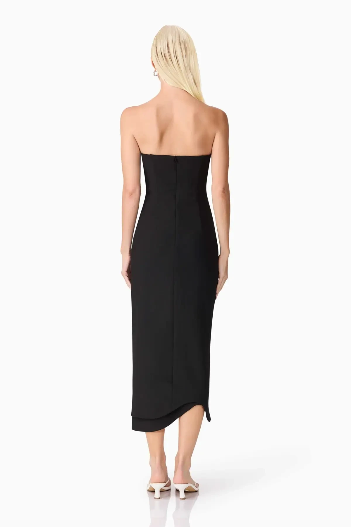 Model is wearing a romantic strapless midi dress with a sweetheart neckline, 3D floral detailing, and a sculptural silhouette that balances elegance and comfort.