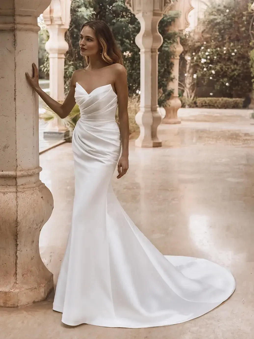 model is wearing a strapless fit and flare bridal gown